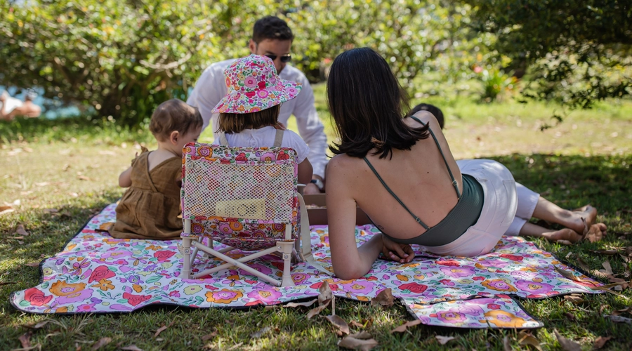 Family picnic on a colourful mat with a baby in an IZIMINI chair
